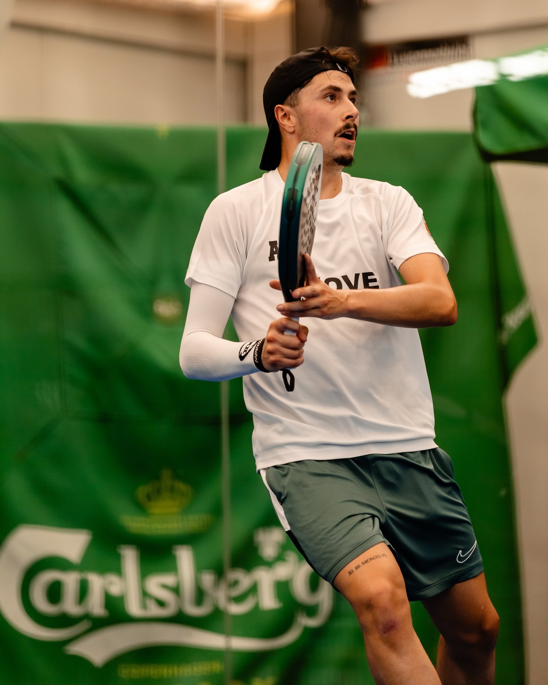 Jogador a bater a bola em frente a uma faixa da Carlsberg
