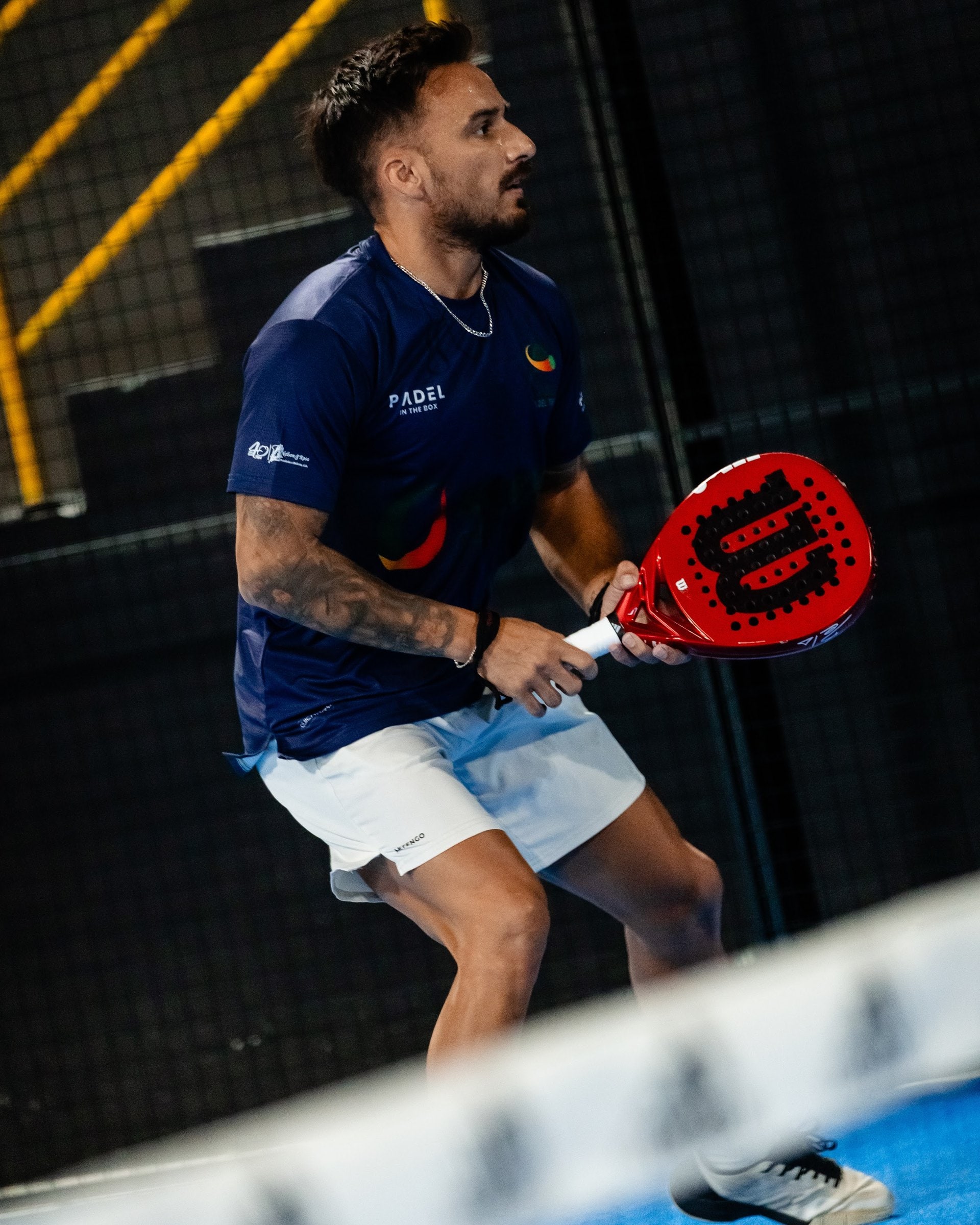 Jogador baixo junto à rede, pronto para o vólei