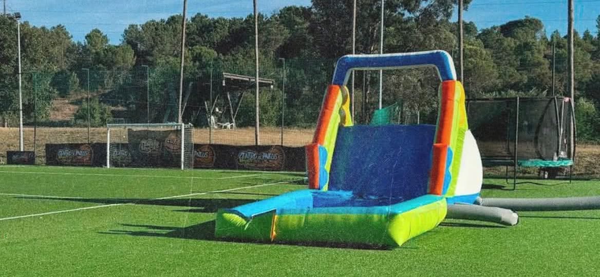 Insuflável montado no campo de futebol de relva sintética do JF79 Sports Center, com trampolim ao lado
